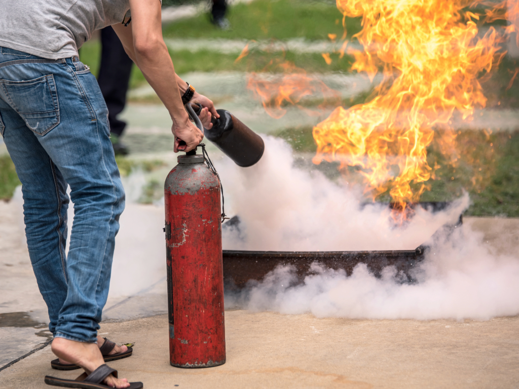 Hombre apagando un fuego con un extintor